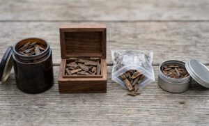 Comparison of glass, wood, and tin agarwood storage containers